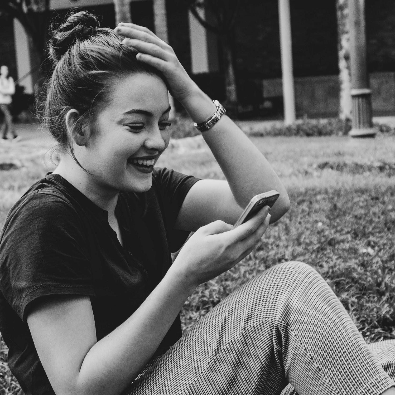 Woman laughing at phone: a funny dating profile and a witty profile description on dating apps like Bumble will make a woman laugh and desire you
